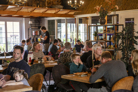 Gezinnen eten samen in de safaritent ‘Tenthouse’ op camping 't Veld in Nederland.