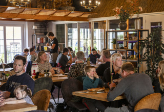 Gezinnen eten samen in de safaritent ‘Tenthouse’ op camping 't Veld in Nederland.