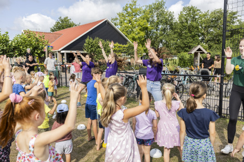Kinderen en volwassenen doen mee aan een buitenactiviteit bij de safari tent Tenthouse op Camping 't Veld.