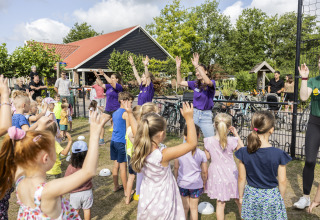 Kinderen en volwassenen doen mee aan een buitenactiviteit bij de safari tent Tenthouse op Camping 't Veld.