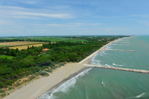 Luftbild vom Strand und Meer bei Dune Agriturismo Ferienpark in Venetien, Italien, mit viel Natur rundherum.