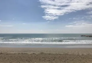 Rolig strand ved Dune Agriturismo i Veneto, Italien, med blødt sand, rolige bølger og let skydække.