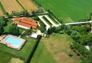 Luftfoto af ferieparken Dune Agriturismo i Veneto, Italien, med grønne marker og swimmingpool.