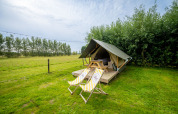 Safari tent Nomad Twin at Holiday Village Knokke in Belgium, set on a grassy field with trees.