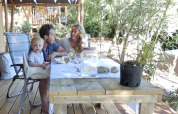 Family enjoying a meal outdoors under a safari tent at Campsite Rosselba le Palme, Italy, sunny day.