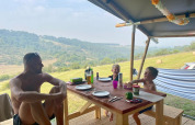 Familia disfruta de una comida en una tienda safari en el camping Les Terrasses de Dordogne en Francia.
