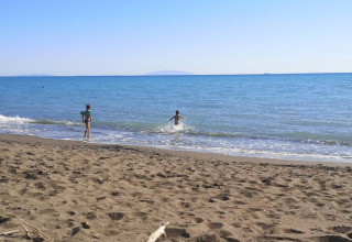 Kinderen spelen aan het strand bij de safaritent met privébadkamer op Agricampeggio La Prugnola in Italië.