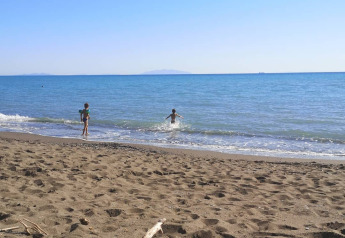 Bambini che giocano sulla spiaggia vicino alla Safaritent con bagno privato ad Agricampeggio La Prugnola in Italia.