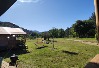 Aussicht von der Lodgetent XL mit Bad auf dem Campingplatz Le Moulin de Cost, umgeben von Natur in Frankreich.