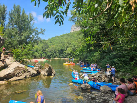 Persone in kayak e che si rilassano sul fiume tra il verde a Camp Redon in Occitania, Francia.