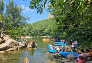 Persone in kayak e che si rilassano sul fiume tra il verde a Camp Redon in Occitania, Francia.