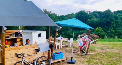 Mensen ontspannen bij een safaritent met privébadkamer op Domaine de La Velle, Frankrijk.