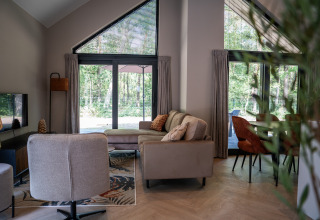 Acogedora sala de estar en Ecovilla Waterzicht Luxe, Holiday park Latour, con vistas al bosque exterior.