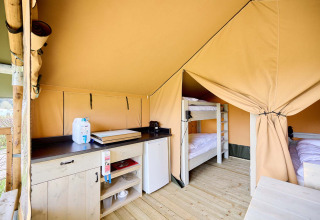Intérieur d'une tente safari Villatent Compact avec cuisine et lits superposés au Camping Rosselba Le Palme, Italie.