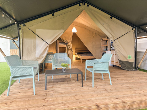 Safari telt med toilet, udstyret med moderne møbler, trædæk og indvendig soveplads, hyggelig atmosfære.