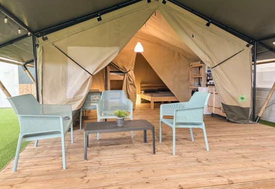 Safari telt med toilet, udstyret med moderne møbler, trædæk og indvendig soveplads, hyggelig atmosfære.