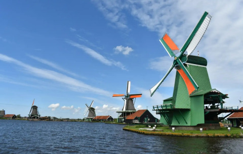 Traditionelle Windmühlen am Wasser im Ferienpark Marina Uitgeest in Nordholland, Niederlande.