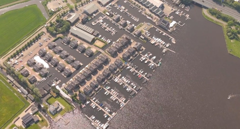 Foto aérea del parque vacacional Marina Uitgeest en Holanda Septentrional, Países Bajos, con barcos y casas.