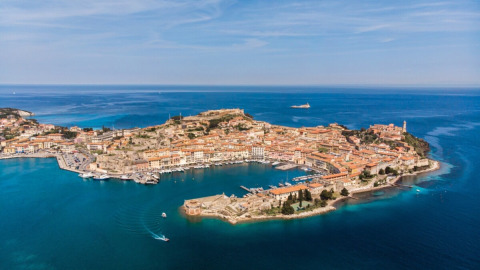 Aerial view of Portoferraio, a historic coastal town on Elba Island in Tuscany, Italy, surrounded by blue sea.