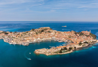 Aerial view of Portoferraio, a historic coastal town on Elba Island in Tuscany, Italy, surrounded by blue sea.