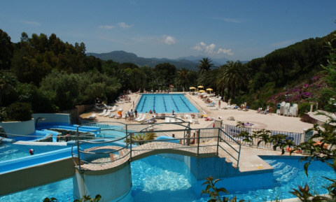 Swimming pool area with waterslides at Campsite Rosselba le Palme, a holiday park in Tuscany, Italy.