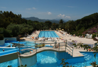 Swimming pool area with waterslides at Campsite Rosselba le Palme, a holiday park in Tuscany, Italy.