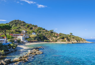 Coastal scenery near Portoferraio, Tuscany, Italy, featuring clear blue waters and hillside homes.