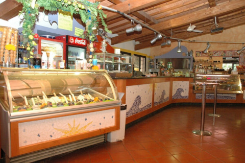 Interno di una gelateria con bancone e bevande nel campeggio Rosselba le Palme in Toscana, Italia.