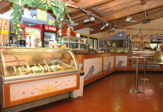 Interno di una gelateria con bancone e bevande nel campeggio Rosselba le Palme in Toscana, Italia.