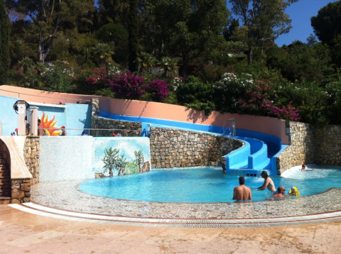 Parco acquatico con scivolo blu e piscina al campeggio Rosselba le Palme in Toscana, Italia.