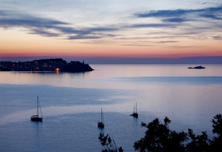Evening sea view with sailboats near the coast, photographed at Campsite Rosselba le Palme in Tuscany, Italy.