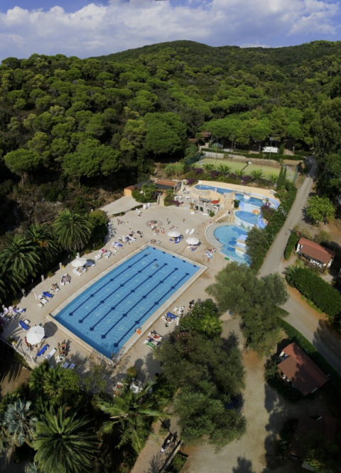 Vista aerea del campeggio Rosselba le Palme in Toscana, Italia, con piscine circondate dal verde lussureggiante.