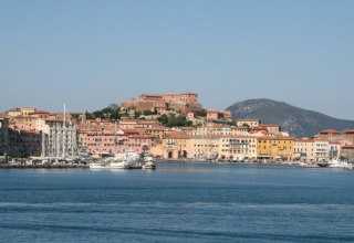 View of the harbor and colorful buildings from Campsite Rosselba le Palme holiday park in Tuscany, Italy.