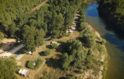 Luftfoto af Campsite La Plage i Occitanie, Frankrig, ved en flod omgivet af træer og campingpladser.