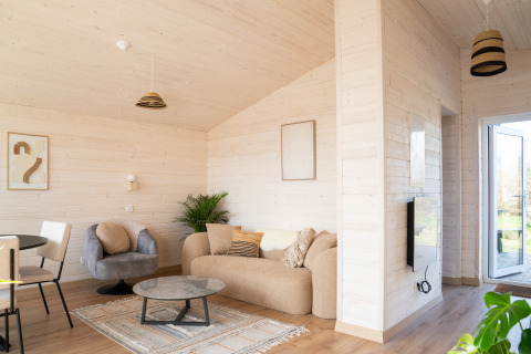 Soggiorno moderno e luminoso allo Slowlodge 2 presso Zomerlicht, Paesi Bassi, con arredi eleganti.