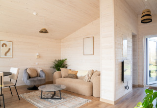 Soggiorno moderno e luminoso allo Slowlodge 2 presso Zomerlicht, Paesi Bassi, con arredi eleganti.