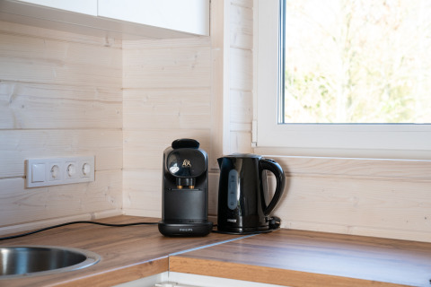 Macchina da caffè e bollitore elettrico su piano di legno nella cucina luminosa di Slowlodge 2, Zomerlicht, Paesi Bassi.
