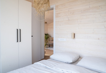 Lyst og moderne soveværelse på Slowlodge 2 ved Zomerlicht i Nederlandene med trægulve og garderobe.