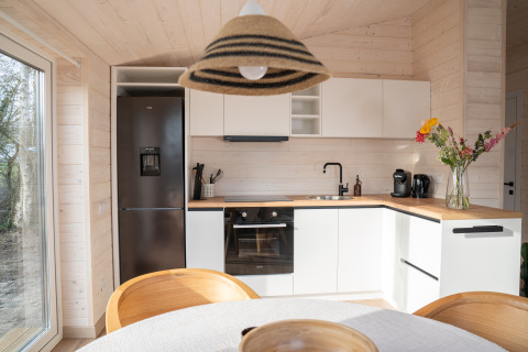 Moderne keuken in Slowlodge Sage bij Zomerlicht, Nederland, met houten afwerking en veel daglicht.