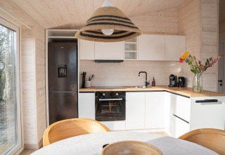 Moderne keuken in Slowlodge Sage bij Zomerlicht, Nederland, met houten afwerking en veel daglicht.