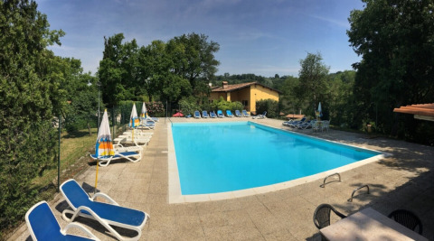Buitenzwembad met ligstoelen en parasols bij Agriturismo Le Sorgive e Le Volpi, Lombardije, Italië.