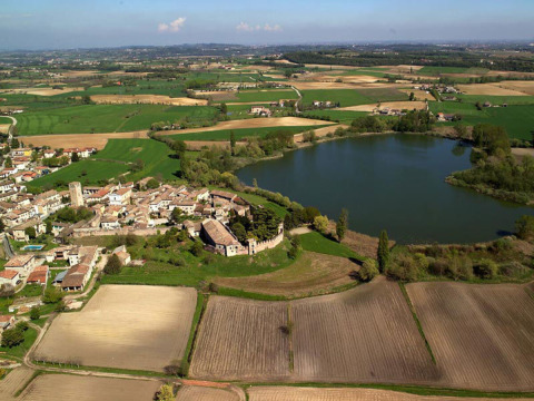 Vista aérea del parque vacacional Agriturismo Le Sorgive e Le Volpi en Lombardía, Italia, junto a campos y un lago.