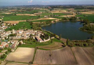 Luftfoto af Agriturismo Le Sorgive e Le Volpi holiday park i Lombardiet, Italien, omgivet af marker og en sø.