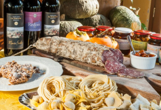 Salchichón italiano, pasta fresca, vino tinto y conservas servidas en un agroturismo en Lombardía.