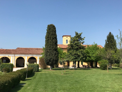 Sonniger Tag im Agriturismo Le Sorgive e Le Volpi in der Lombardei, Italien, mit grünen Rasenflächen.