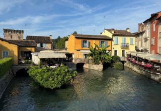 Kleurrijke gebouwen aan het water bij Agriturismo Le Sorgive e Le Volpi, Vodatent, Lombardije, Italië op zonnige dag.