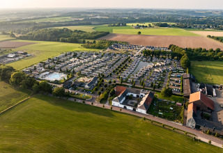 Luchtfoto van Resort Mooi Bemelen in Nederland, met lodges, groene velden en landelijke omgeving.