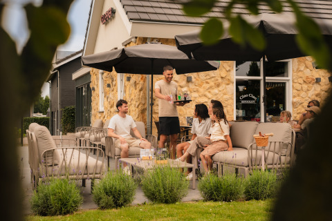 Terras bij Schaelsbergerbosch - Garden House & Resort Mooi Bemelen met gasten en bedienend personeel.