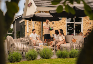 Terras bij Schaelsbergerbosch - Garden House & Resort Mooi Bemelen met gasten en bedienend personeel.