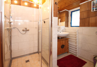 Moderne badeværelse med brusekabine, vask, trægulv og vindue i Holiday home 'Susanne 58 qm' i Tyskland.